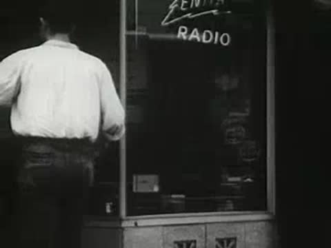 Man walking past a radio shop storefront window, vintage urban scene.