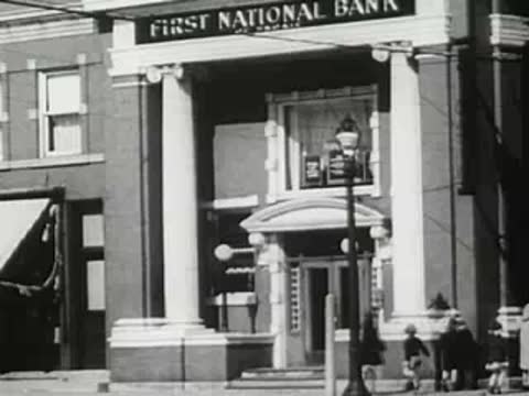 First National Bank facade with columns and pedestrians on sidewalk