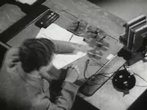 Person working at desk with papers and telephone in office.