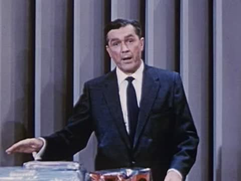 man gesturing towards a table displaying various packaged products