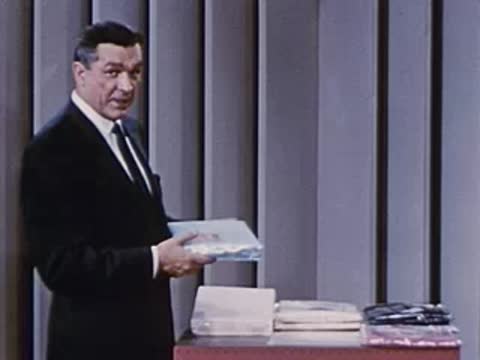 man picking up a flat packaged item from the table display