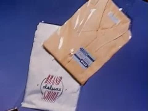 Overhead view of various packaged clothing and pastry box on surface