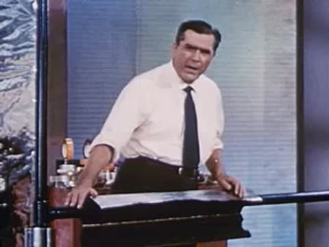 man standing behind a table with various objects on it