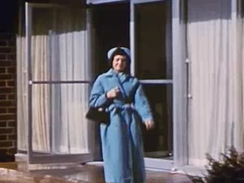 Woman in blue coat enters building exterior, followed by close-up of pickles