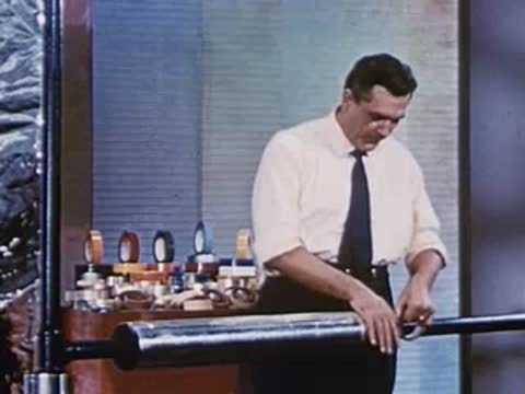 man using adhesive tape on a metallic roller on a table