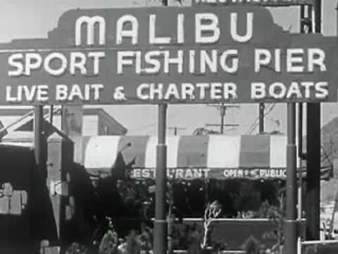Sign for Malibu Sport Fishing Pier with charter boat information overhead.