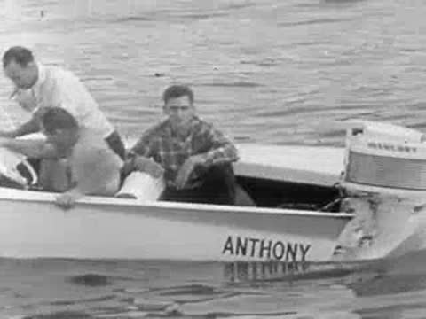 A motorboat with people on board accelerates quickly across the water.