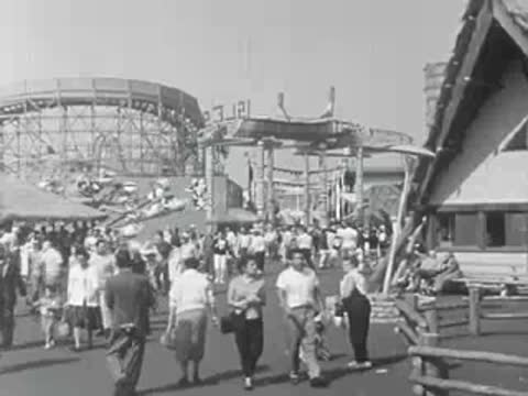 Crowds of people walking along a pathway inside Pacific Ocean Park.