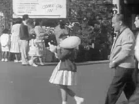 A young girl holds a balloon while walking through the park.