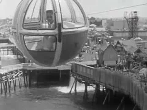 Cable car passing over the water near the amusement park pier.