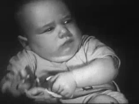 Infant lying down and looking towards the side.