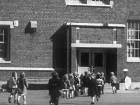 Children walking out of a school building entrance.