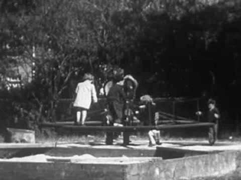 Children playing on a merry-go-round playground ride.