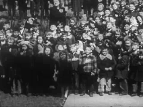 Crowd of children standing together outdoors during a school event.