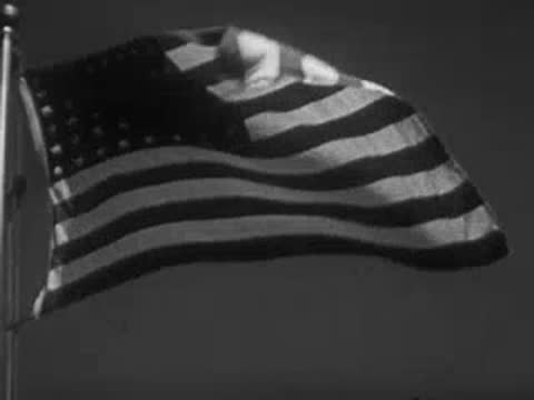 American flag waving in the wind on a flagpole.