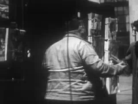 Man standing by a podium giving a presentation indoors.
