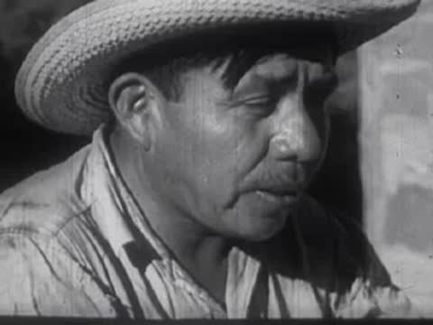 Man wearing a straw cowboy hat looking sideways in profile view outdoors.