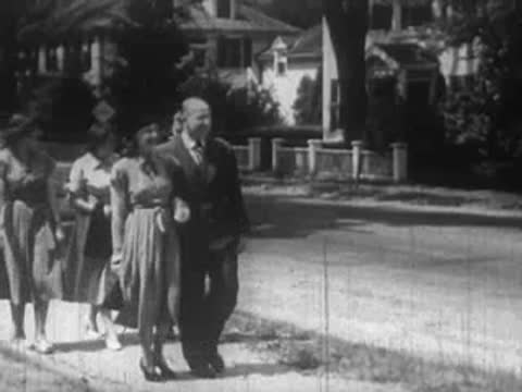Group of three people, two women and a man, walking together outdoors.