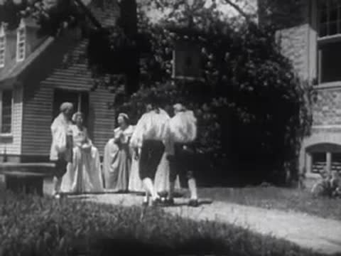 A group of people in historical clothing walking together along a path.