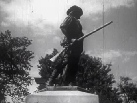 A statue of a soldier with a rifle standing on a pedestal outdoors.