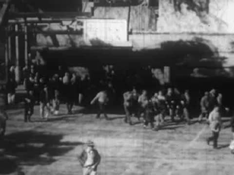 Large crowd of people moving through an outdoor urban plaza or square.