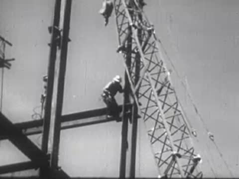 Industrial workers welding metal structures on a building facade under construction