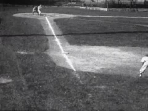 People playing baseball on a grassy field, vintage sports scene