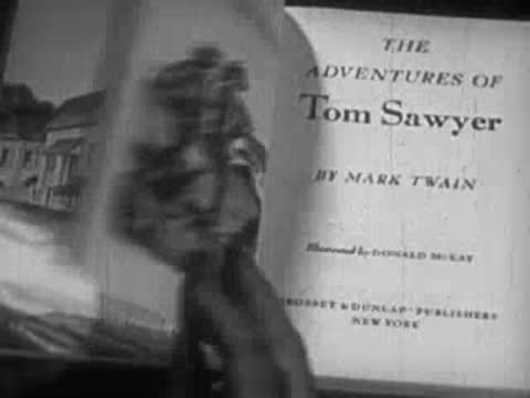 Open book displaying illustrations and title page of The Adventures of Tom Sawyer by Mark Twain