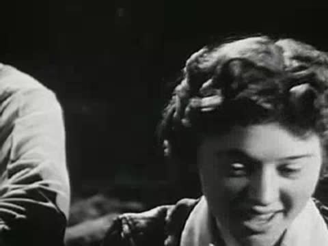 Close-up of a young woman smiling and laughing near a campfire