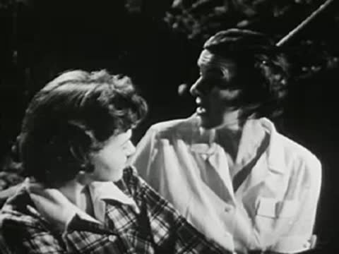 Teenage girl and woman talking together outdoors at night