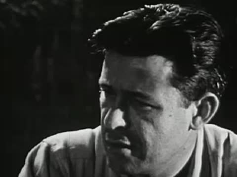Man talking intently outdoors at night, mid-20th-century shirt