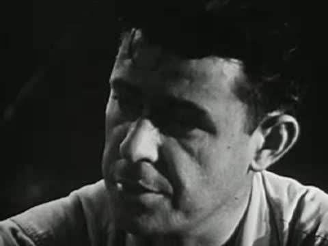 Man talking seriously outdoors at night, mid-20th-century setting