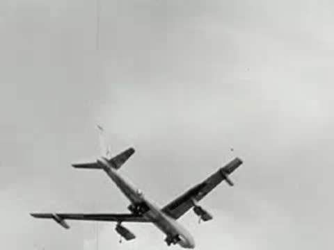 B-52 bomber in mid-flight banking against a cloudy sky