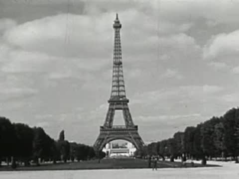 Eiffel Tower seen from a park with trees and clear sky in Paris