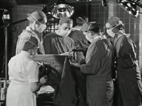 Surgeons performing an operation in a hospital operating theater, medical staff