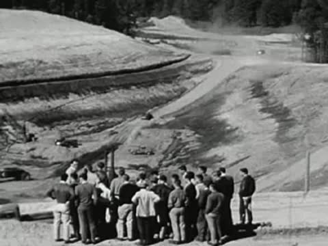 Group of men gathered in a hilly landscape, construction or outdoor engineering site