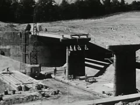 Bridge construction site with concrete pillars and scaffolding in a rural area