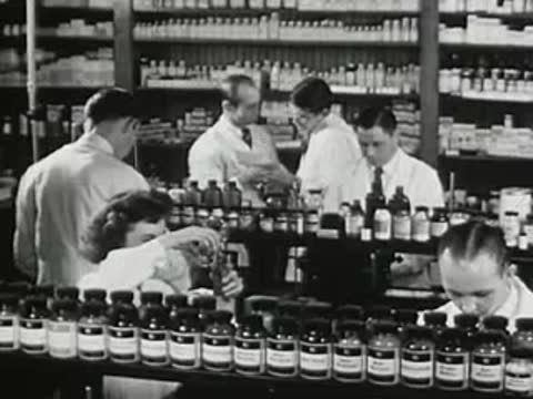 Students and technicians working with chemicals in a chemistry laboratory setting