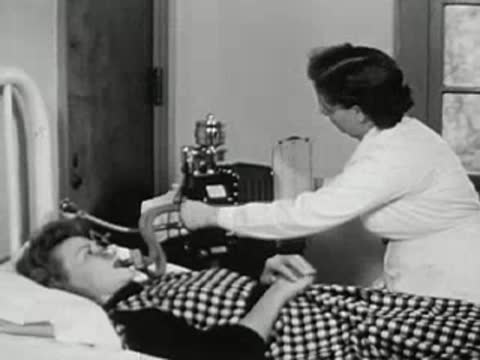 Medical professional operating X-ray equipment on a patient lying on a bed