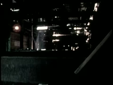 A worker descending into a dark industrial space or machinery pit.