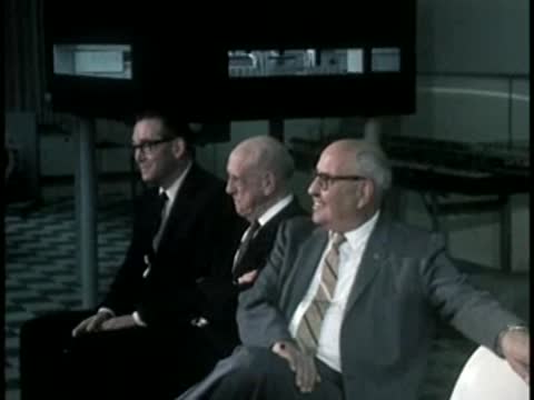 Men in suits seated indoors, mid-century modern design