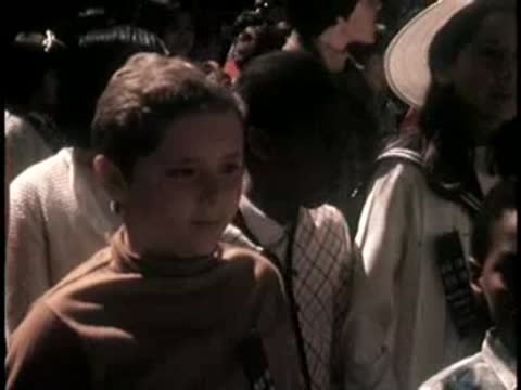 Close-up of a young boy smiling in a crowd