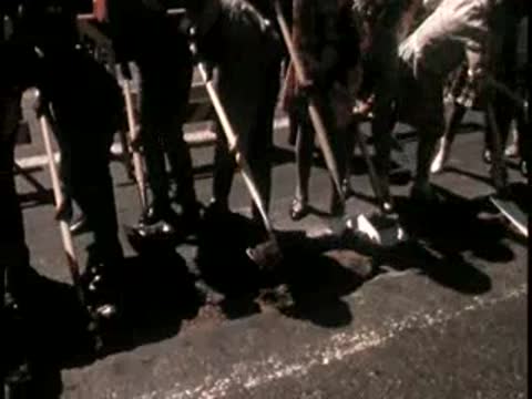 Ground-level view of people gathered with ceremonial shovels