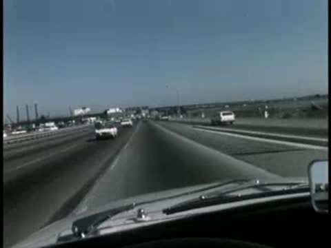 POV driving shot from inside a truck cab on a multi-lane highway.