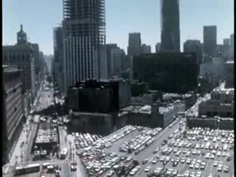 High angle view of downtown cityscape with dense parking lots.