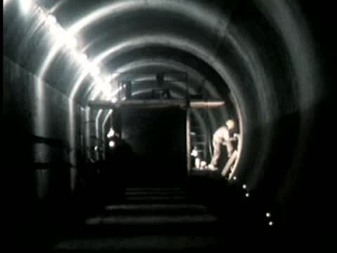 POV shot moving slowly through a brightly lit curved tunnel.