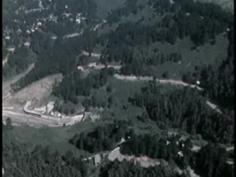 Aerial panoramic view of green hillside landscape and winding roads.