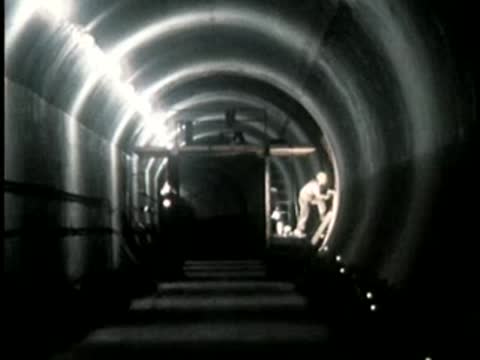 Dark underground tunnel with construction lighting and worker