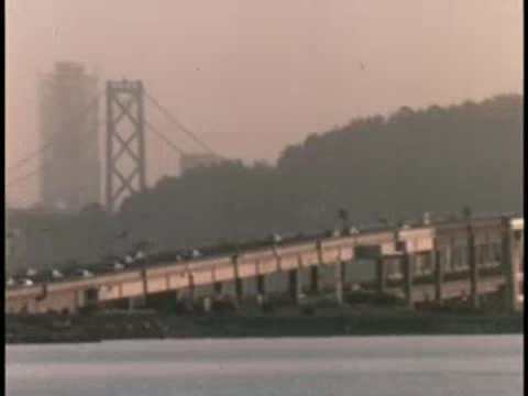 Bridges over water with hills in the background during daylight.
