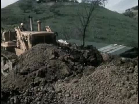 Bulldozer moving earth on a hillside construction site